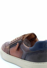 Sneaker in pelle marrone con superficie texturizzata, accenti scuri a contrasto, una zip decorativa e suola in gomma beige. Lacci piatti e interno imbottito.