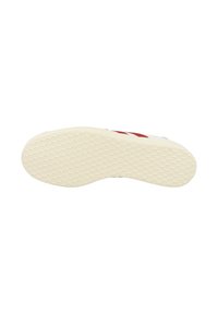 Shoe sole in cream rubber with hexagonal grip pattern. Features red and white stripes indicating the upper design. Textured surface for traction.