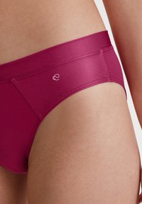 Lila naadloze slipjes met een brede tailleband. Kenmerkt zich door een klein wit logo en gladde, rekbare stof voor comfort.