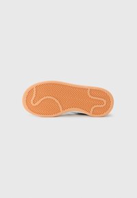 Rubber shoe sole with an orange hue, featuring a zigzag patterned tread. Smooth texture with rounded contours at the edges.