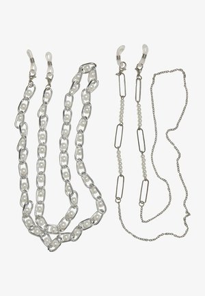 Neli aksessuaaride ketti: üks suurte hõbedaste linkide ja valgete helmedega, üks väikeste linkidega ja valgete pärlitega, ning kaks tavalist hõbedast ketti.