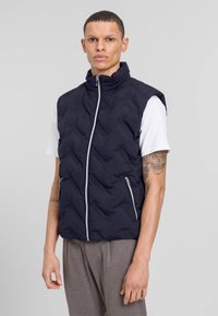 Marineblaues Steppweste mit hohem Kragen, durchgehendem Reißverschluss und zwei seitlichen Taschen. Bietet eine gesteppten Textur und ein elegantes Design.