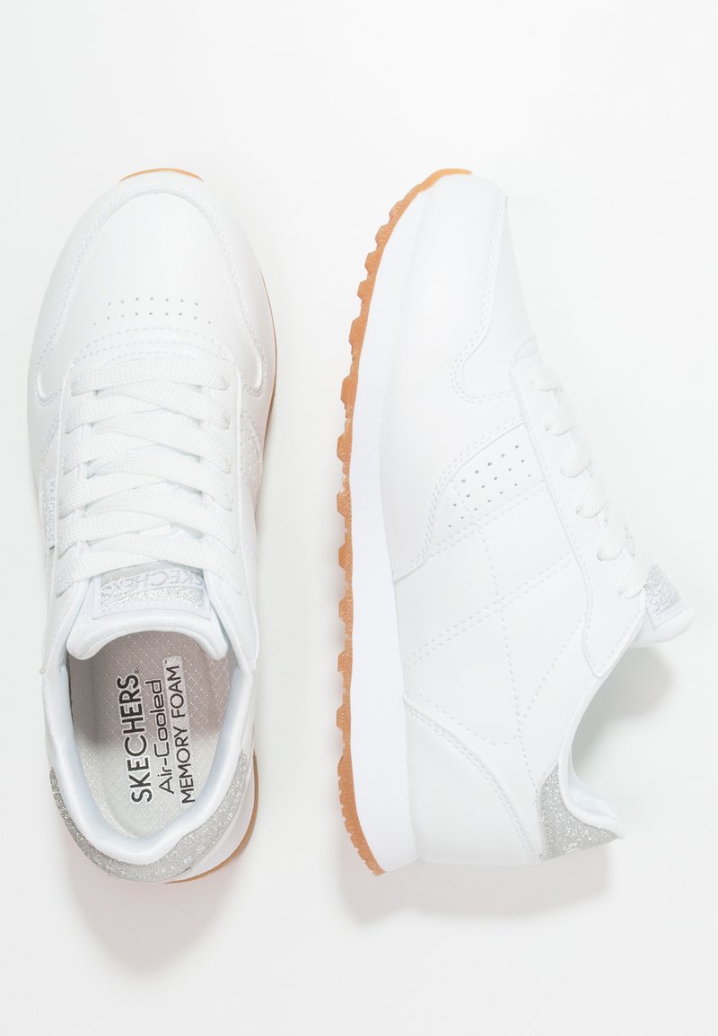 Witte sneakers met een gladde synthetische bovenkant en een geribbelde rubberen zool. Voorzien van zilveren accenten en een vetersluiting. Zachte, gewatteerde binnenzool.