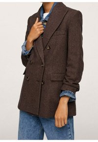 Bruine houndstooth double-breasted blazer met inzetsels, knoopdetails en twee zijzakken, gedragen over een denim blouse.