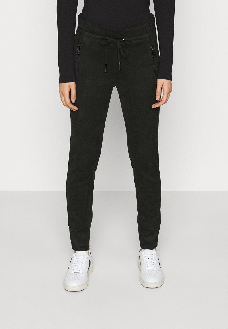 Mörkgrön träningsoverallsbyxor i ett mjukt material, med dragsko i midjan och dragkedjefickor fram. Smal passform med avsmalnande ben.