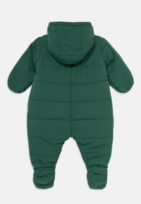 Sötétzöld, párnázott baba hóruha kapucnival, hosszú ujjú és zárt lábbal, hátulról bemutatva, fehér háttéren.
