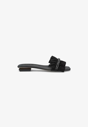 Black slide sandal with a textured fabric bow and beaded accent. Features a low square heel and a smooth insole. Simple, elegant design.