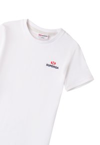 Camiseta de algodón blanca con mangas cortas, cuello redondo, que presenta un pequeño logo rojo y marino en el pecho. Diseño sencillo y clásico.