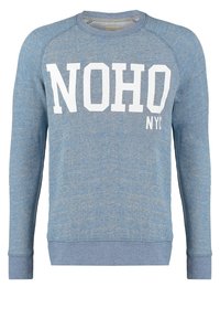 Blue, textured sweatshirt with long sleeves. Features bold white text "NOHO NYC" on the front. Ribbed neck and cuffs. Casual design.