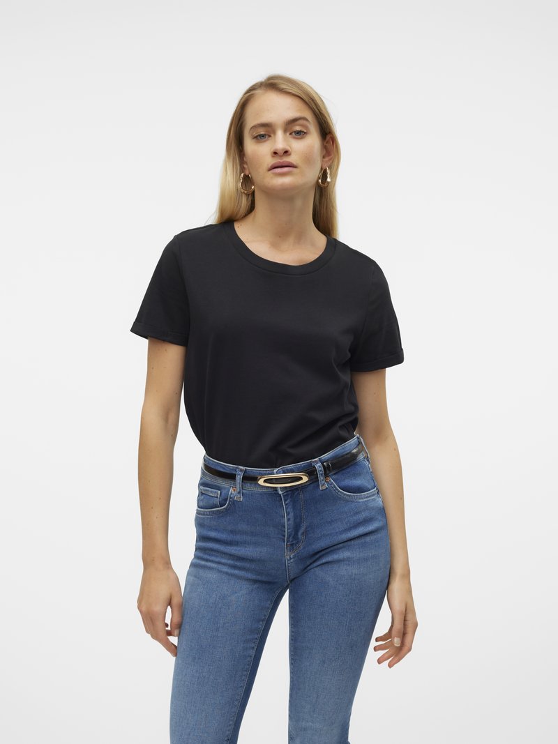Svart bomullst-skjorte med korte ermer og rund hals, kombinert med blå høytlivsjeans og et svart belte med en gull oval spenne.