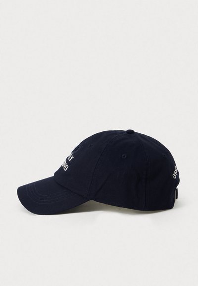 Sötétkék baseballsapka hímzett fehér szöveggel és állítható pánttal, oldalnézetből bemutatva, egy sima világos háttér előtt.