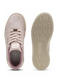 Lys rosa sneaker med tekstureret læderoverdel, perforeret design, flade snørebånd og en beige gummisål. Guldfarvet akcent på hæltaben.