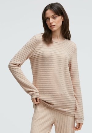 Hellbeiger Pullover mit langen Ärmeln und Rippenstruktur, Rundhalsausschnitt und seitlichen Schlitzen, kombiniert mit passenden gerippten Hosen.