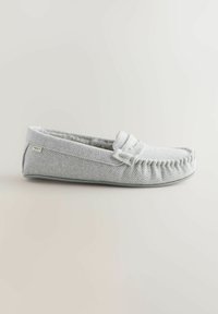 Pantofole grigie con texture, design cucito, rivestimento morbido e suola piatta. Presentano un fiocco decorativo sulla parte anteriore e un piccolo cartellino.