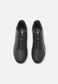 Mustat urheilukengät, joissa on virtaviivainen muotoilu, sileää synteettistä materiaalia, valkoisia yksityiskohtia ja perinteinen nauhoitusjärjestelmä.