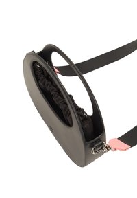 Borsa crossbody in silicone nero con forma ovale, dotata di un compartimento in tessuto arricciato, dettagli rosa e tracolla regolabile.