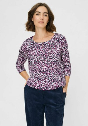 Lila Bluse mit floralem Muster, dreiviertel Ärmeln, runder Halslinie und Schlüssellochdetail; strukturierter Stoff mit glatter Oberfläche.