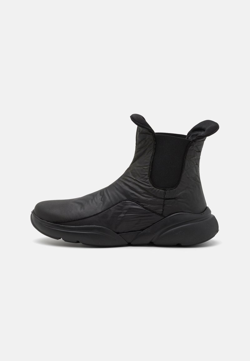 Schwarze Knöchelstiefel aus gestepptem Material mit elastischen Seitenpaneelen, runder Spitze und strukturiertem Gummisohle für besseren Halt.