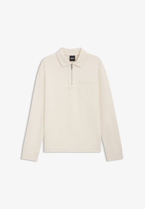 Langärmeliges Poloshirt in Cremefarben mit einem Reißverschluss am Kragen, einer Brusttasche und gerippten Bündchen. Hergestellt aus weichem Stoff, zeichnet es sich durch klare Linien und ein minimalistisches Design aus.