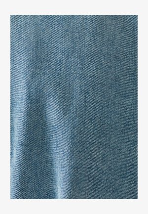 Tela de mezclilla azul claro con una textura tejida, que muestra sutiles variaciones en el tono y un acabado suave.