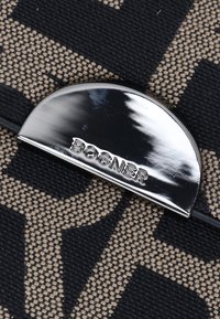 Tejido tejido en negro y beige con un patrón audaz; hardware semicircular brillante en plata con el logo "BOGNER" grabado.