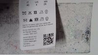 Vaskelapp for vevde plagg med tekst og symboler. Hvit bakgrunn, svart trykk, inkluderer QR-kode, rengjøringsinstruksjoner og størrelse detaljer.