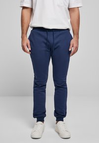 Marineblå joggebukser lavet af blød bomuldsblanding, med elastisk linning med snøre og ribstrikkede manchetter ved anklerne.