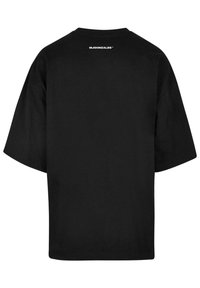 Camiseta negra de manga corta con cuello redondo, que presenta un logo impreso en la parte superior de la espalda. Fabricada en suave tela de algodón.