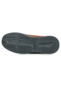 Suola di scarpa in pelle marrone con una presa in gomma nera testurizzata, caratterizzata da un motivo a zigzag e branding inciso sul tallone.