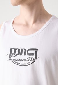 Witte katoen tanktop met een zwart bedrukte logo waarop "mng Paradise Disco Dancing Club" staat, met een ronde halslijn en een zachte textuur.