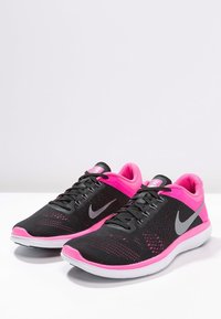 Scarpe da atletica nere e rosa con parte superiore in rete, logo swoosh grigio e suola bianca. Presentano un collare imbottito e un sistema di allacciatura.