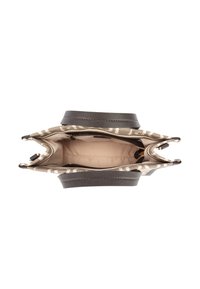 Beżowa torba na ramię w wzory z ciemnobrązowymi uchwytami, otwarta, aby pokazać beżowe wnętrze i zasuwaną kieszeń wewnętrzną.