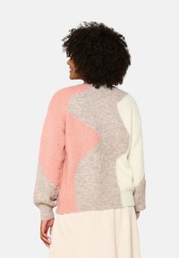 Knit sweater featuring a color-block design with pink, beige, and off-white sections. Round neckline and slightly puffed sleeves.