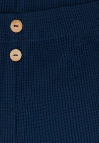 Marineblauwe wafelbrei stof met een ribbelstructuur, voorzien van twee houten knopen op de tailleband.
