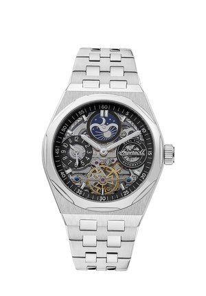 Montre en acier inoxydable argenté avec un cadran noir, design ajouré mettant en valeur les mécanismes, affichage duale de l'heure et chiffres larges.