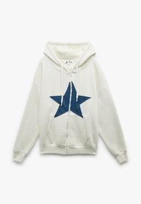 Weiße Zip-Up-Hoodie mit einer großen blauen Jeansstern-Applikation auf der Vorderseite. Der Stoff ist weich und verfügt über verstellbare Kordeln an der Kapuze.