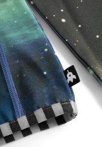 To stykker stofprøver med himmelske designs. Den ene i grøn-blå nuancer, den anden mørk med hvide prikker; begge har sort-hvide ternede accenter.