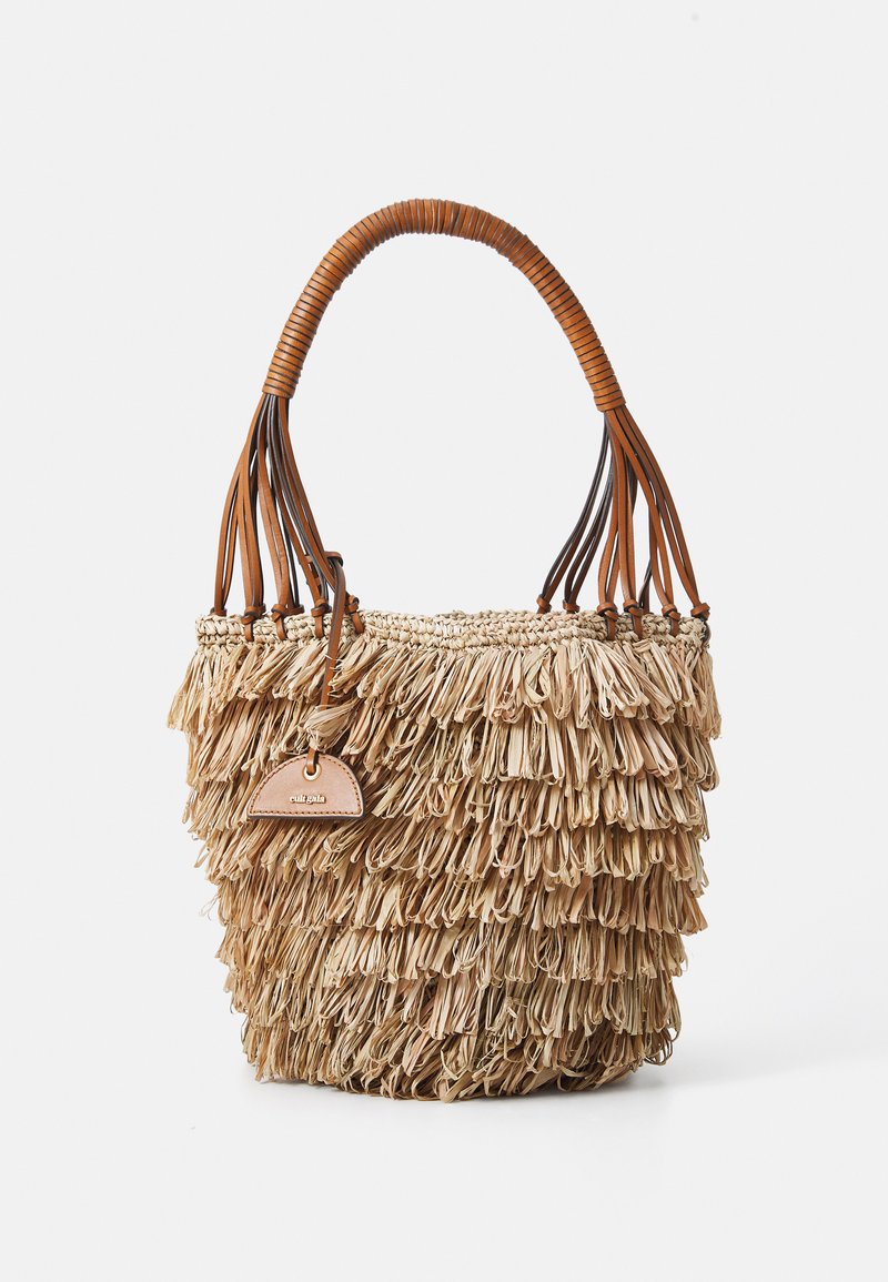 Vävd halmhandväska med fransdetaljer, bruna läderhandtag och en liten läderetikett, med en rund charm med en logotyp.