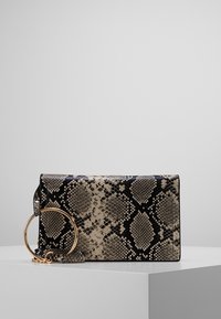 Pochette à motif de peau de serpent en beige et noir avec une poignée circulaire en or et une bandoulière amovible, forme rectangulaire, texture lisse.