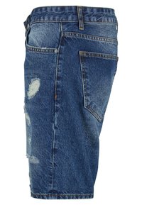 Denim šorti ar vidēju zilu tonējumu, nolietotiem akcentiem un klasisku griezumu. Ietver piecas kabatas un redzamu šuvju.