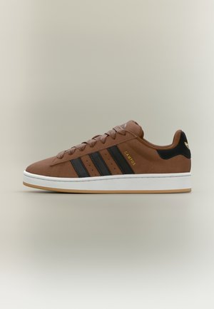 Brun Adidas Campus sneaker med sorte striber, hvid sål og gummi ydersål vist fra siden på neutral baggrund.