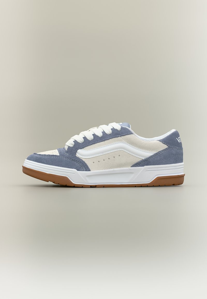 Χαμηλό αθλητικό παπούτσι με πάνελ από λευκό και γκρι σουέντ, λευκά κορδόνια, σόλα από καουτσούκ gum και λευκή πλευρική ρίγα σε ουδέτερο φόντο.