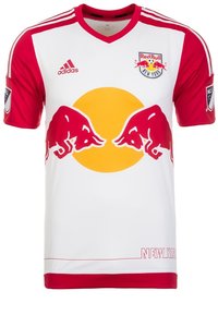 Bílý fotbalový dres s červenými rukávy, na přední straně velký žlutý kruh a logo dvou červených býků. Na spodní části nápis "NEW YORK".