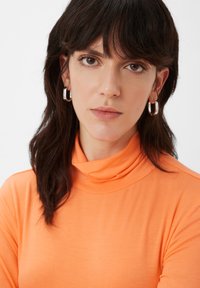 Helder oranje coltrui gemaakt van zacht materiaal. Korte mouwen met een gladde, lichte textuur en een slim fit silhouet.