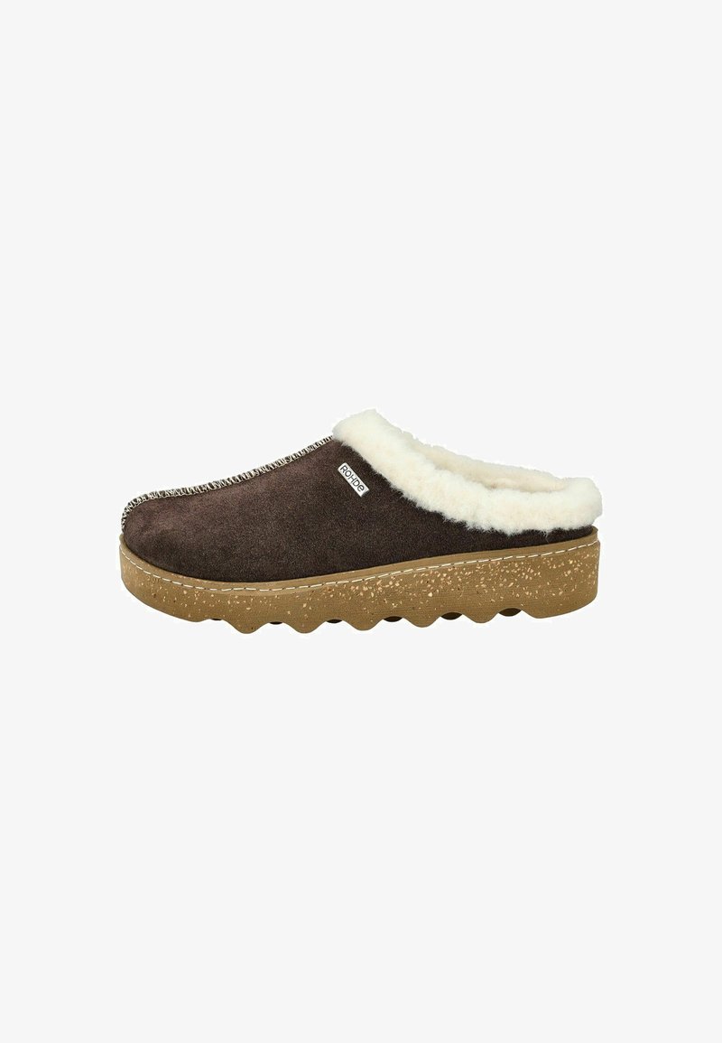 Sabot en suede marron, à enfiler, avec doublure en fausse fourrure blanche, semelle en caoutchouc texturé et couture décorative le long du bord supérieur.