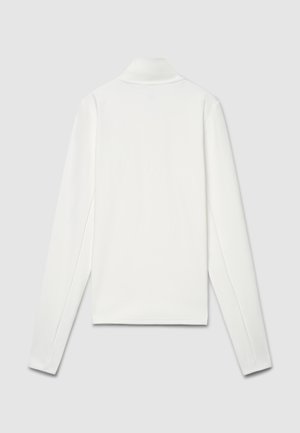 Polo blanc à manches longues avec col plat, texture lisse, fentes latérales et marquage minimal au dos. Coupe et design uniformes.