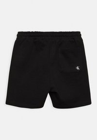 Shorts in cotone nero con elastico in vita, dotati di tasca posteriore e un piccolo logo bianco sul lato destro. Texture liscia.