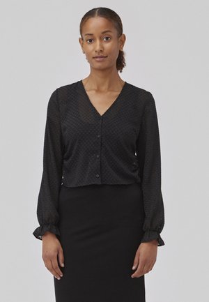 Black, textured, sheer blouse with a V-neck and button front. Long sleeves with gathered cuffs. Worn over a black pencil skirt.