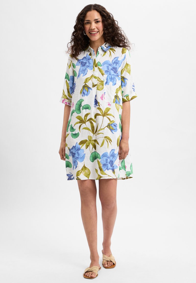 Korte mouwen, overhemdjurk met een bloemenprint van blauwe en groene bloemen op een witte achtergrond. Gemaakt van lichtgewicht stof.