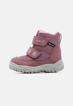 Børns lyserøde vinterstøvle med velcroremme, snefnugdesigns, Gore-Tex label og tyk struktureret sål til udendørs brug.